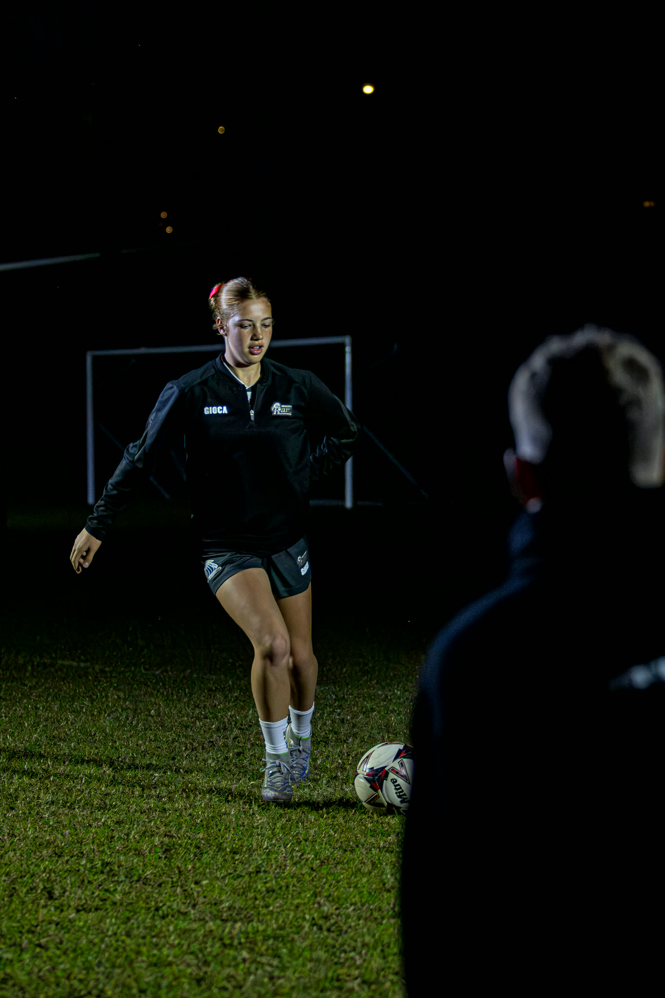 A player training under lights during an evening session.
